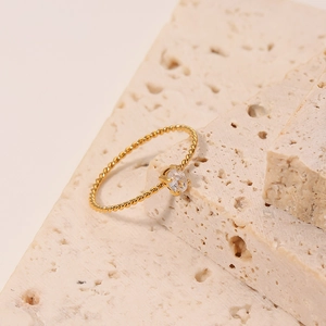 Elegant gold twisted rope ring featuring a clear oval zircon in a four-prong setting