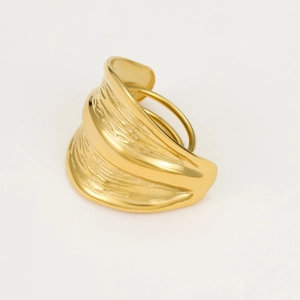 Macro shot of gold wide-band ring with wavy texture on a clean white background