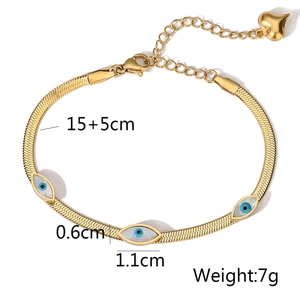 Detail of gold snake chain bracelet with evil eye charms and heart pendant