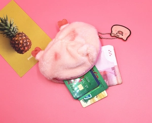 Detail of pink plush pig coin purse showing inner capacity for cards and folded cash