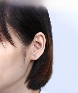 Close-up of minimalist S925 sterling silver four-prong round zircon stud earring on ear