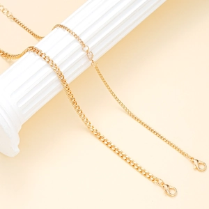 Golden stainless steel heart zircon anklet set displayed on elegant white Roman pillars
