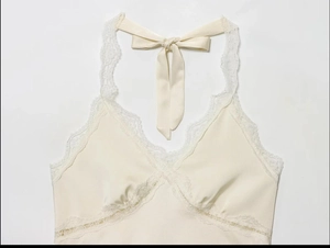 Detailed view of the lace neckline and satin fabric on the cream halter top camisole