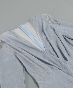 Detail view of the deep V-neckline and silver fringe on this light blue glitter bodysuit