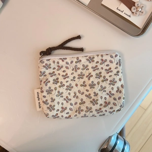 Close-up of floral linen pouch with simple wish label and rustic zipper pull cord
