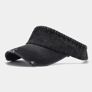 Detail view of distressed charcoal denim sun visor with vintage frayed edges and texture