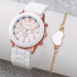 Close-up of Geneva quartz watch with white strap and gold heart bracelet on gift stand