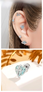 Macro detail of heart cross stud earring with light blue zircon on white stone