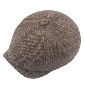 Detailed view of brown herringbone pattern fabric on a classic newsboy cap