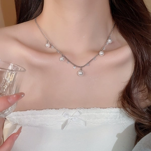 Close-up of elegant pearl tassel necklace with zircons worn on model collarbone