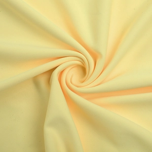 Detailed texture of creamy yellow backless evening dress fabric with soft ribbed knit finish
