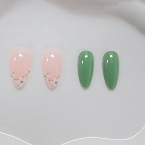 Elegant almond press-on nails with white flower patterns and solid dark green finish