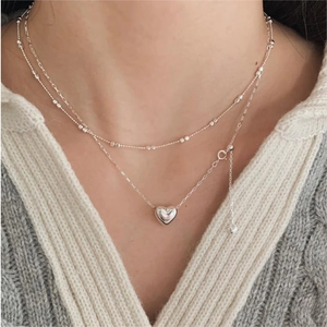 Layered 925 sterling silver necklaces with heart pendant and bead chain on model