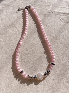 Detail of pink cat-eye stone necklace with baroque pearl and silver lobster clasp