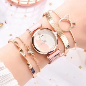 Close-up of pink quartz watch with cat dial and four matching gold bracelets on wrist