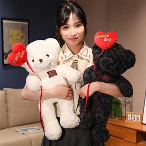 Detail of white and black teddy bears with red heart balloons and embroidered tags