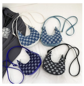 Flat lay of denim crescent bags in four colors featuring checkerboard patterns and raw edges