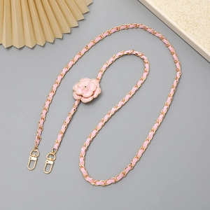 Detail of pink camellia phone strap with gold chain, leather ribbon, and pearl accents