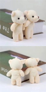 Detalle de mini osos de peluche que muestra la suave textura de punto y el lazo colgante