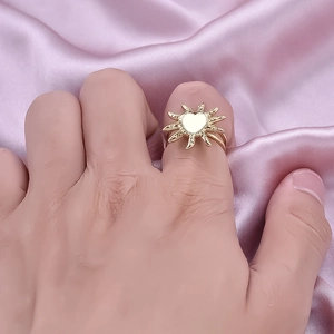18K gold plated stainless steel sunburst ring with white heart center worn on finger