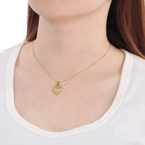 Golden heart pendant necklace with snake chain worn by a model on a white shirt
