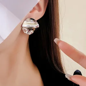 Asymmetric silver hoop earrings with irregular folded texture and liquid metal finish
