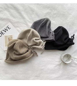 Detailed view of ribbed knit beanies in brown, beige, grey, and black with drawstring