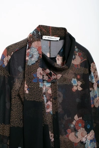 Close-up of vintage floral chiffon blouse featuring an elegant scarf collar and buttons