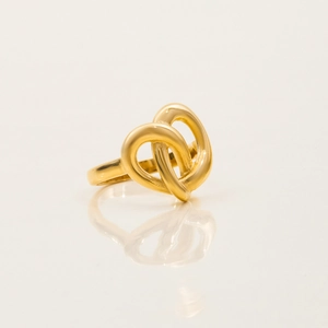 Macro shot of gold stainless steel heart knot ring with mirror reflection effect