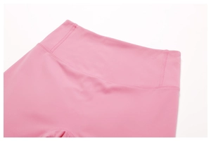 Close-up of high-waist yoga shorts with wide elastic waistband and pink sports fabric