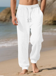 Détail du pantalon d'été blanc pour hommes avec taille à cordon et texture en maille
