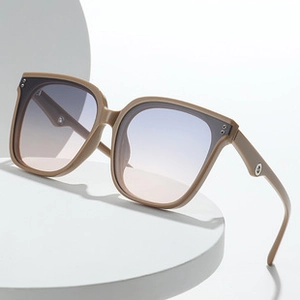 Detail of flame-shaped sunglasses with blue to pink gradient lenses and metal studs