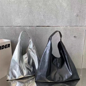 Détail de grands sacs hobo en cuir souple brillant argenté et noir au style minimaliste