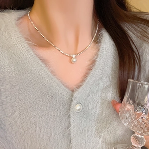 Elegant silver crushed chain necklace featuring a single pearl on a fashion model