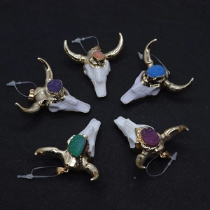 Detailed set of bull skull pendants with colorful crystals on a black textured background