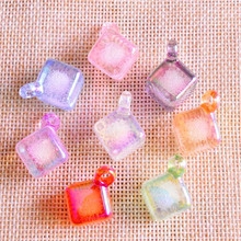 Macro shot of colorful square resin glass pendants with hanging holes on linen fabric