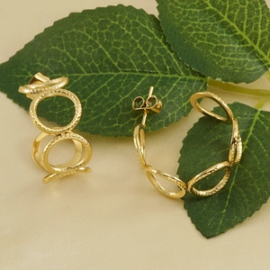 Textured 18K gold plated multi-ring link stud earrings on elegant silk fabric
