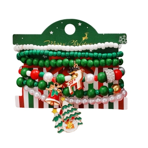 Dettaglio di set braccialetti di Natale con ciondoli alce, campana e albero su cartoncino