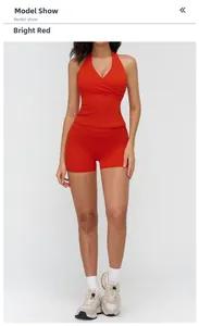 Macro view of women's red brushed yoga set featuring a halter cross-neck top and high-waist shorts