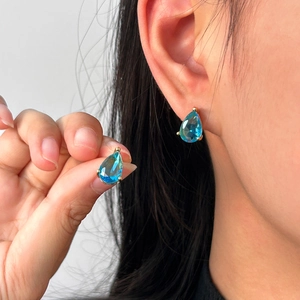 18K gold plated stainless steel stud earrings with blue teardrop zircon on a model