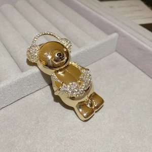 Detailed close-up of a golden bear brooch with micro-paved crystals on jewelry display