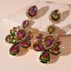 Close-up of sparkling colorful teardrop rhinestone earrings on white stone