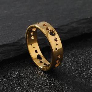 Detail view of gold titanium steel ring featuring evenly spaced hollow heart patterns