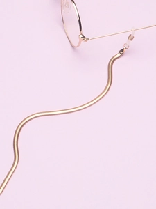 Close-up of golden snake chain eyewear strap with adjustable silicone loop ends