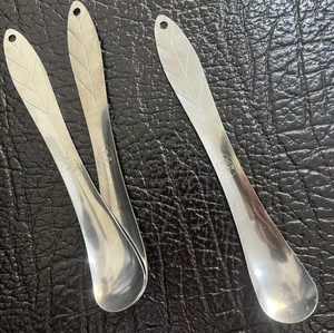 Dettaglio macro di cucchiai in acciaio inossidabile a forma di foglia con incisione 304