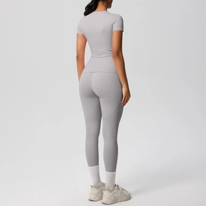 Rear view of grey high-stretch yoga set showing back contours of fitted short-sleeve top