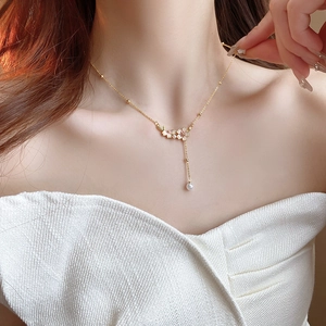 Elegant gold flower necklace with white pearls and cherry blossoms on female model