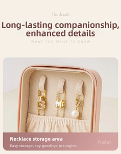 Detail view of pink jewelry box featuring three necklace hooks and elastic storage pocket