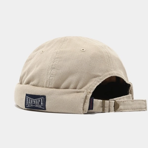 Beige corduroy brimless docker hat with vintage metal buckle and side label detail