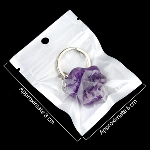 Purple crystal cat paw keychain in clear packaging bag with dimensions labeled